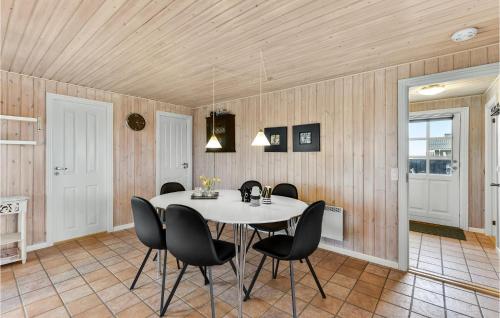 a dining room with a white table and black chairs at Holiday Home Arvidvej Hvide Sande Xii in Bjerregård