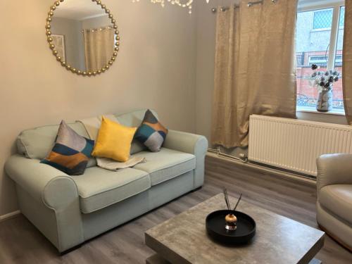 a living room with a couch and a table at HavilaHome Retreat in Manchester