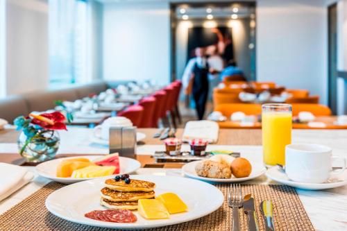 a table with plates of breakfast food on it at Medellin Marriott Hotel in Medellín