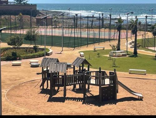 a park with a playground with a slide at Appartement pied sur mer- resid férmé- pscine in Tamaris