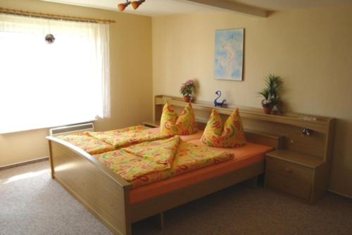 ein Schlafzimmer mit einem Bett mit gelben und orangefarbenen Kissen in der Unterkunft Ferienhaus Figelski in Sassnitz