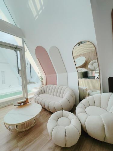 a living room with white furniture and a mirror at 朵2包棟Villa in Xiaoliuqiu