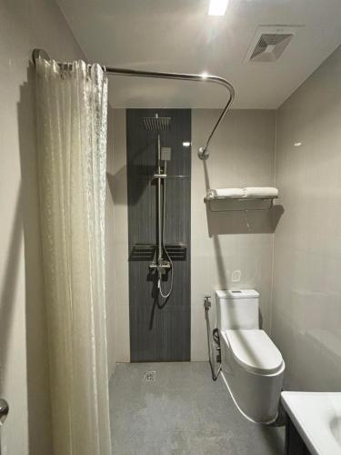 a bathroom with a toilet and a shower at El Coco Boutique Hotel in Ibabang Talim