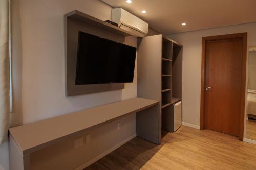 a living room with a flat screen tv on a wall at Pousada Zammá Gramado in Gramado