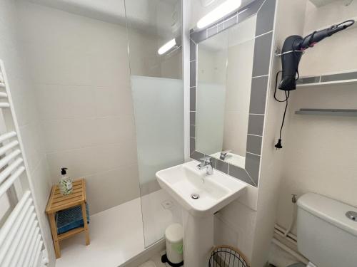une salle de bain blanche avec un lavabo et un miroir dans l'établissement Appartement lumineux en centre-ville d'Arcachon, proche commerces, balcon, 4 couchages - FR-1-474-191, à Arcachon