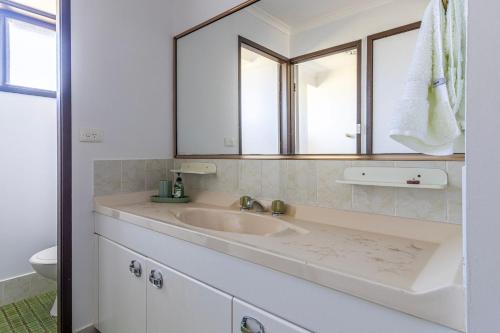 a bathroom with a sink and a mirror at Bayt Baytak in Sussex inlet