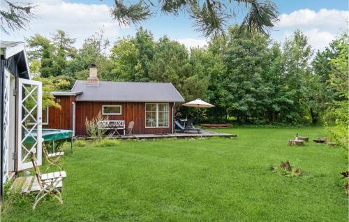 a log cabin in a yard with a green lawn at Awesome Home In Nykøbing Sj With Wifi in Klint