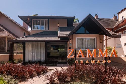 a house with a zaminarmaarma sign in front of it at Pousada Zammá Gramado in Gramado