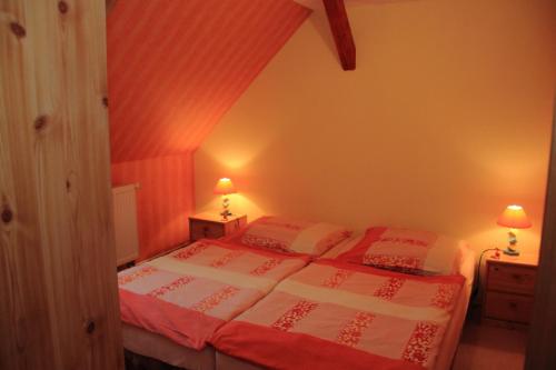 Schlafzimmer mit einem Bett mit roter und weißer Bettwäsche in der Unterkunft Ferienwohnung Krug in Sassnitz