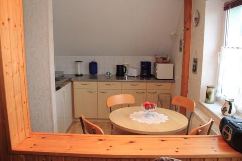ザスニッツにあるFerienwohnung Krugのキッチン(テーブル、テーブル、椅子付)