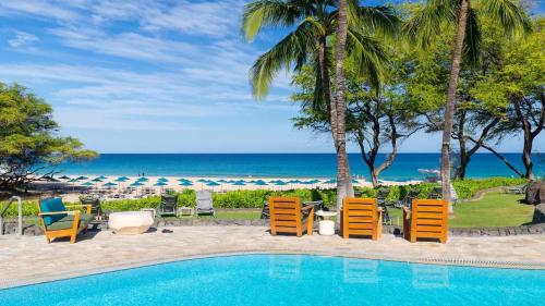 a swimming pool with chairs and the beach at ❤PiH❤ OCEAN BREEZE Panoramic Ocean View Mauna Kea Resort Optional Privileges in Waimea