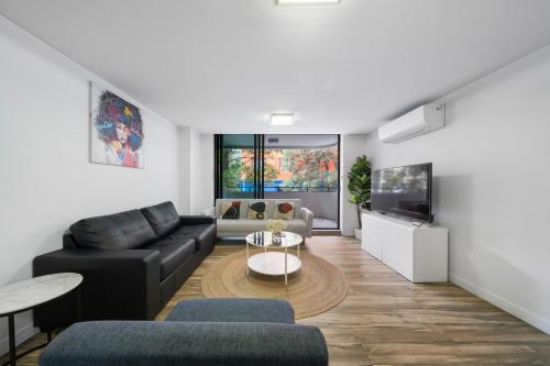 a living room with a couch and a table at Delicated ICC & Darling Harbour 3BR Apt with Parking in Sydney