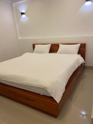 a bedroom with a bed with white sheets and pillows at B2 Hotel Savannakhet in Savannakhet