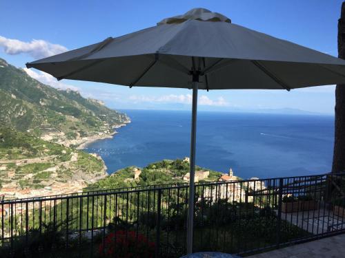an umbrella sitting on top of a balcony next to the ocean at La Casa di Vania in Ravello