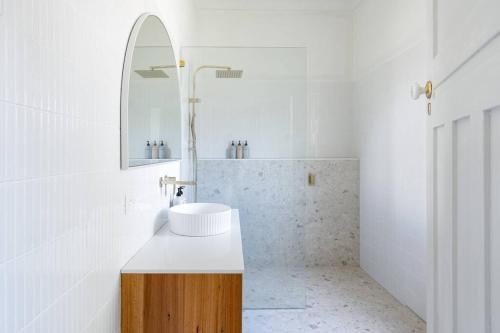 a white bathroom with a sink and a mirror at Charming Family-Friendly Home in Kings Park