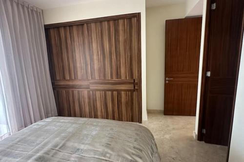 a bedroom with a bed and a wooden closet at Comfort at Club De Golf el Tigre in Nuevo Vallarta 