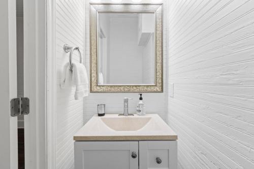 a white bathroom with a sink and a mirror at Cozy Downtown Seneca Bungalow in Seneca