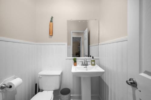 a white bathroom with a toilet and a sink at Woodlands Area Lake View Retreat in Conroe