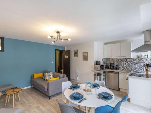 une cuisine et un salon avec une table et des chaises dans l'établissement Appartement Centre Cauterets, Confort Moderne, Cuisine Équipée - FR-1-401-307, à Cauterets