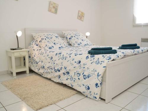 - un lit blanc avec une couette bleue et blanche dans l'établissement Villa avec piscine et wifi, 6 pers, Le Barcarès - FR-1-81-624, au Barcarès