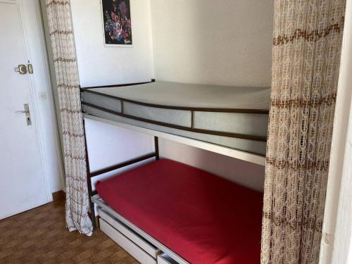- une chambre avec des lits superposés et un matelas rouge dans l'établissement Studio cabine 4 pers, terrasse, parking, Cap d'Agde naturiste - FR-1-249A-42, au Cap d'Agde