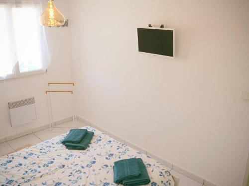 une chambre avec un lit avec deux oreillers verts dessus dans l'établissement Villa avec piscine et wifi, 6 pers, Le Barcarès - FR-1-81-624, au Barcarès