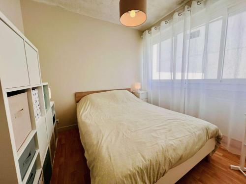 une petite chambre avec un lit et une fenêtre dans l'établissement Appartement confortable 2 pièces avec balcon et parking à Quiberon - FR-1-478-304, à Quiberon