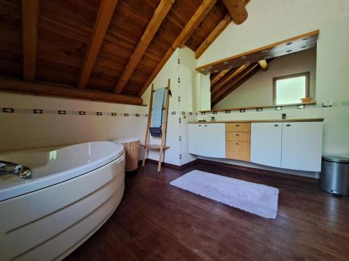 une grande salle de bain avec une baignoire et un lavabo dans l'établissement Chalet 4* 8 pers, Animaux admis, Wifi, Parking à Valloire - FR-1-263-542, à Valloire