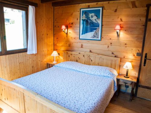 une chambre avec un lit dans une cabane en rondins dans l'établissement Chalet spacieux 4 chambres près pistes, Le Grand-Bornand - FR-1-467-134, au Grand-Bornand