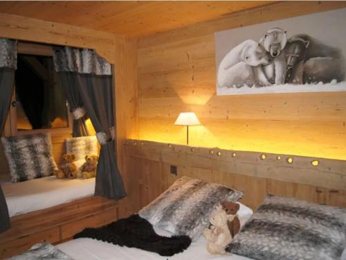 une chambre avec deux lits dans une cabane en rondins dans l'établissement Charmant chalet 4 pers avec cheminée au Grand-Bornand - FR-1-467-137, au Grand-Bornand
