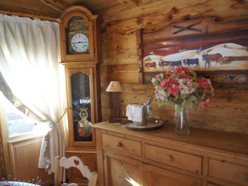 Cette chambre en bois dispose d'une horloge et d'un vase de fleurs. dans l'établissement Charmant appartement près des pistes, parking inclus - FR-1-467-138, au Grand-Bornand