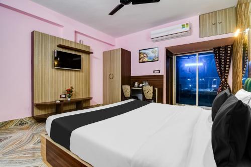 a bedroom with a bed and a desk and a window at Hotel O Fifteen in Kolkata