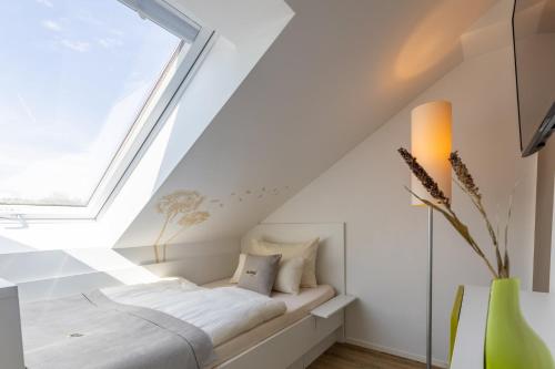 a bed in a room with a window at Candlewood Suites Fürth by IHG in Fürth