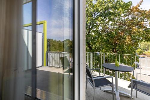 a balcony with a table and chairs and a window at Candlewood Suites Fürth by IHG in Fürth