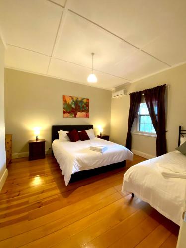 a large bedroom with two beds and a window at Tanunda Central Cottage in Tanunda