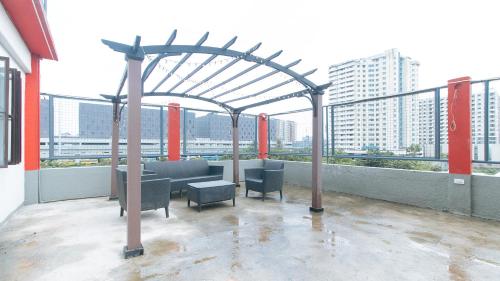a rooftop patio with a seating area on a building at RedDoorz Plus near Tambo Paranaque in Manila