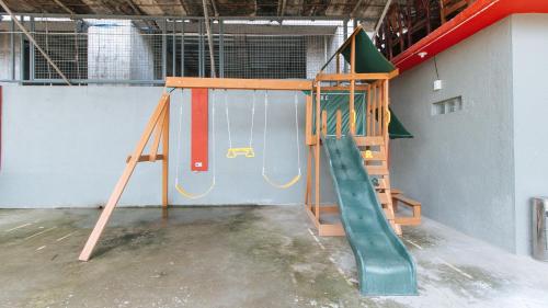 a playground with a slide in a room at RedDoorz Plus near Tambo Paranaque in Manila