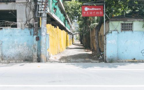 an empty street with a sign on the side of a building at RedDoorz Plus near Tambo Paranaque in Manila