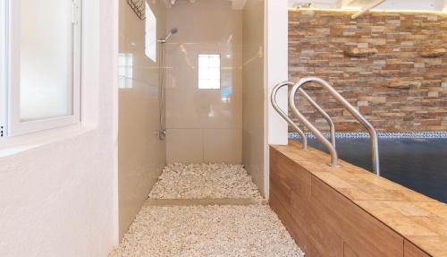 a bathroom with a walk in shower next to a window at RedDoorz Plus near Tambo Paranaque in Manila