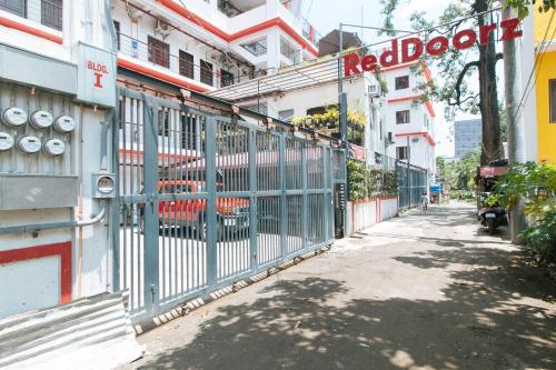 a gate on the side of a building with a red door at RedDoorz Plus near Tambo Paranaque in Manila