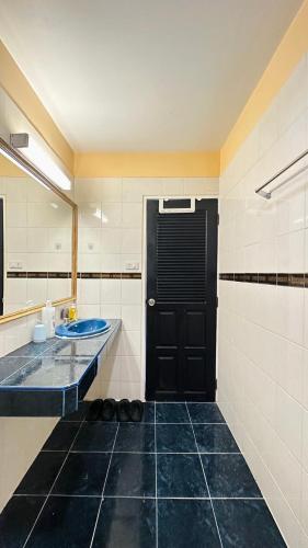 Un baño con lavabo y puerta negra. en Seoul Boutique Hotel 서울부티크호텔 首尔精品酒店, en Pattaya central