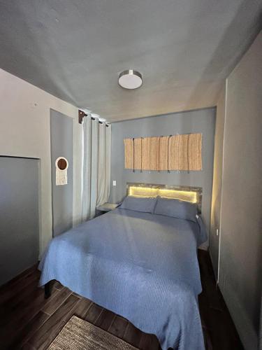 a bedroom with a bed with a blue bedspread at Hotel Spa Casa del Sol in Guanajuato