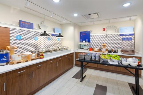 a kitchen with wooden cabinets and bananas on a counter at Holiday Inn Express & Suites - Abingdon by IHG in Abingdon
