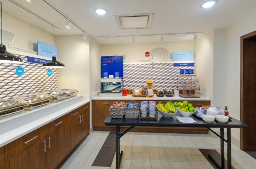 a kitchen with bowls of fruit on a table at Holiday Inn Express & Suites - Abingdon by IHG in Abingdon