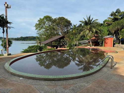 a pool of water with a building and a lake at Koh Mak Buri Hut Natural Resort in Ko Mak