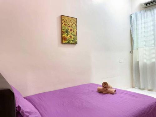 a teddy bear sitting on top of a purple bed at CozyHouse 4ROOM 3BATH ROOM 10PAX```SimpangAmpatTasek in Simpang Ampat