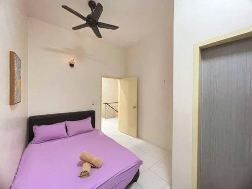 a bedroom with a purple bed and a ceiling fan at CozyHouse 4ROOM 3BATH ROOM 10PAX```SimpangAmpatTasek in Simpang Ampat