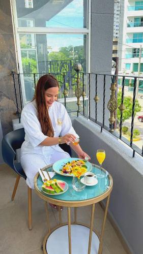 a woman sitting at a table with a plate of food at Mantra Hotel Boutique in Santa Marta