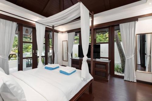 a bedroom with a white bed with windows at Renovated Luxury 3 Bed Pool Villa Kirikayan Maenam Koh Samui in Amphoe Koh Samui