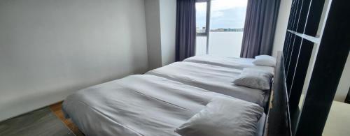 a couple of beds in a room with a window at Sungsan Marina Hotel in Seogwipo